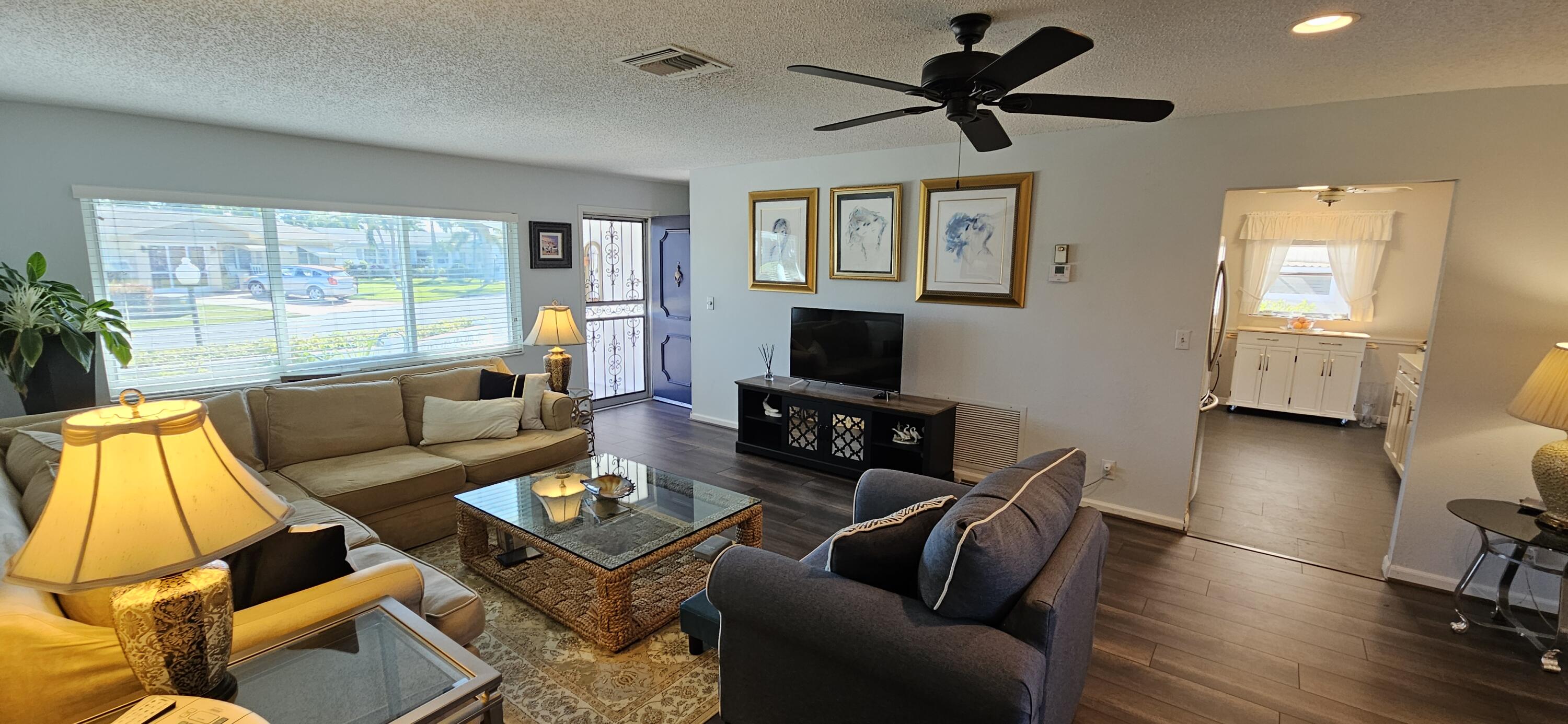 5213 Michael Drive West Palm Beach, FL 33417 - Photo 7 of 47 a living room with furniture and a flat screen tv with wooden floor