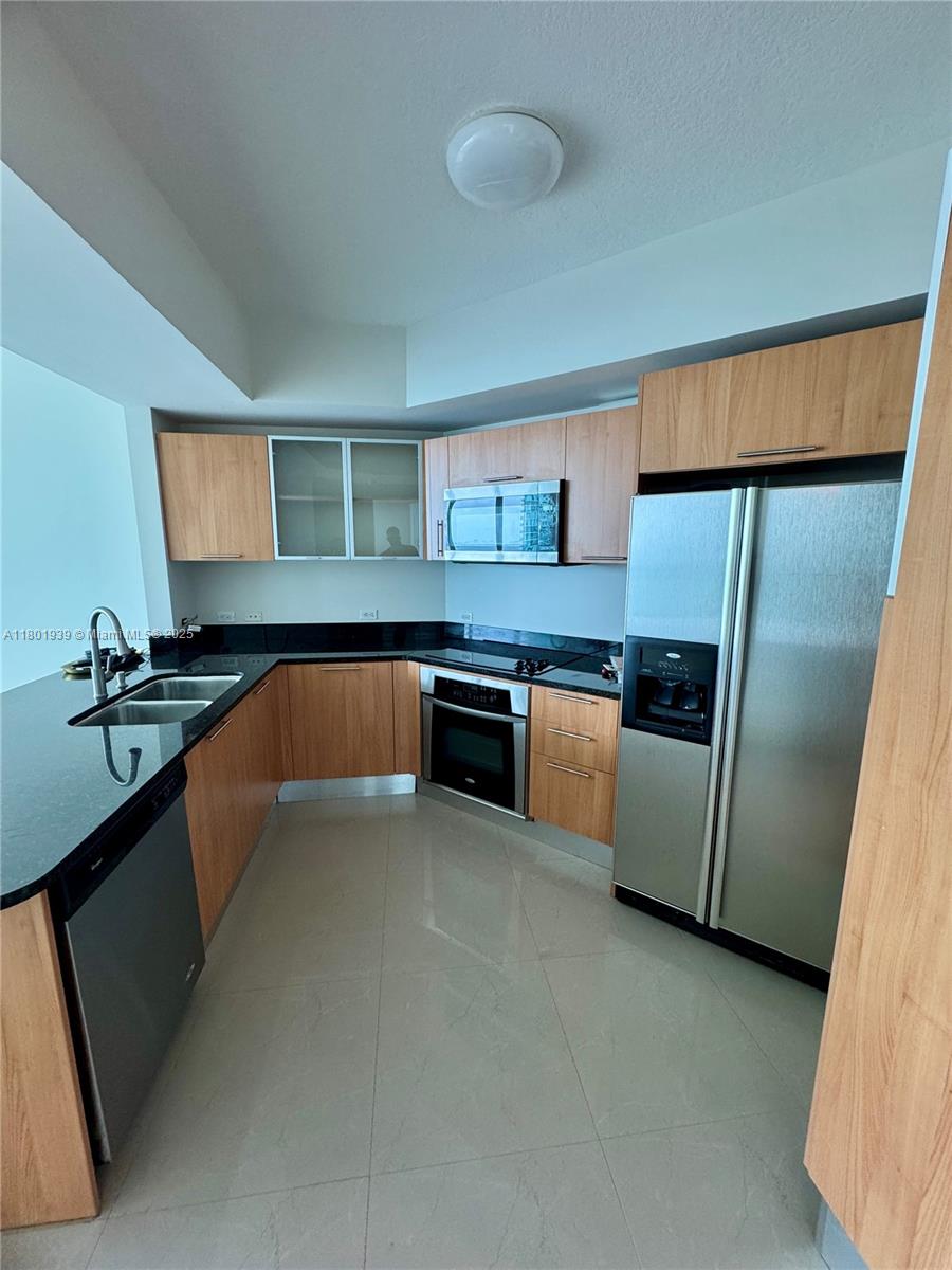 Edgewater Miami, FL 33137 - Photo 8 of 31 a kitchen with stainless steel appliances granite countertop a sink and a refrigerator