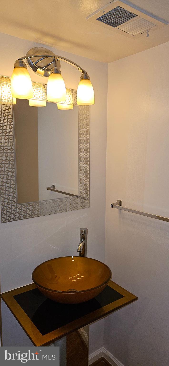 12332 Rollys Ridge Avenue, Unit 2105 Upper Marlboro, MD 20774 - Photo 14 of 31 a bathroom with a sink and a mirror