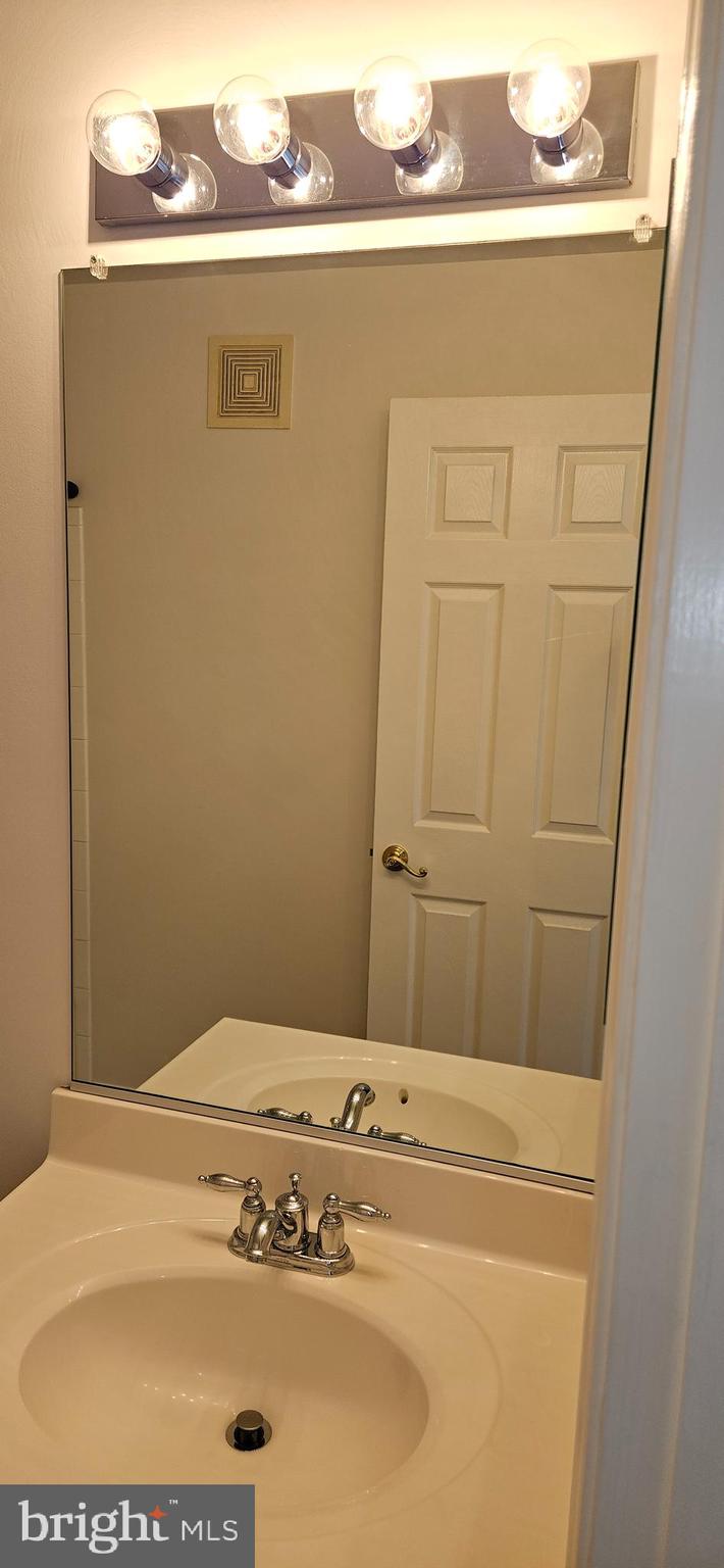 12332 Rollys Ridge Avenue, Unit 2105 Upper Marlboro, MD 20774 - Photo 17 of 31 a bathroom with a sink and a mirror