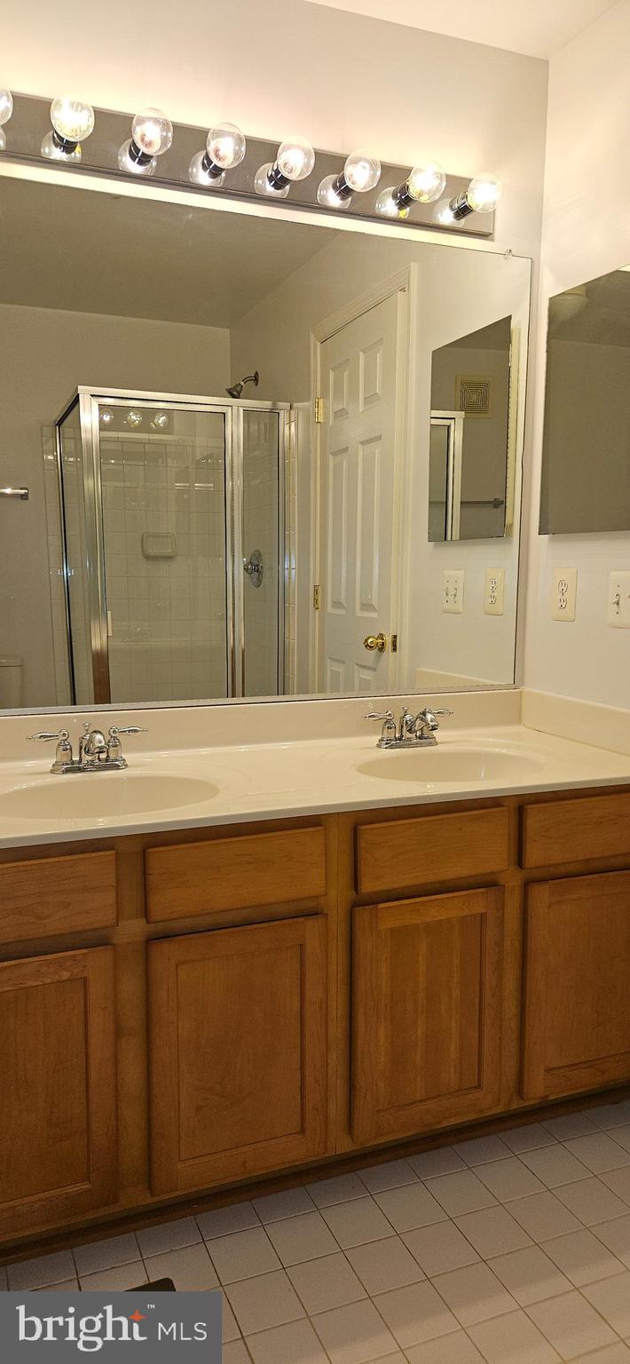 12332 Rollys Ridge Avenue, Unit 2105 Upper Marlboro, MD 20774 - Photo 22 of 31 a bathroom with a double vanity sink and mirror