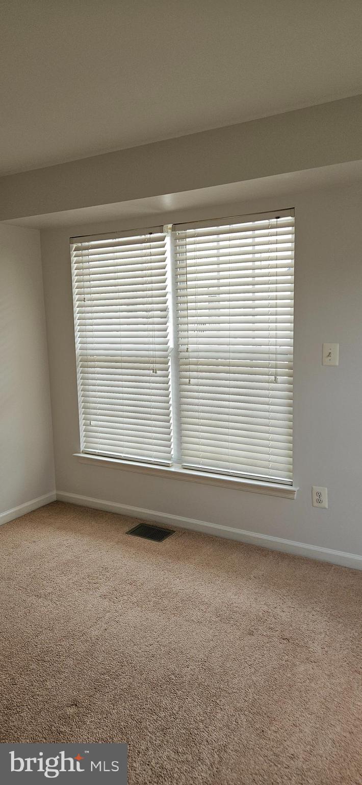 12332 Rollys Ridge Avenue, Unit 2105 Upper Marlboro, MD 20774 - Photo 28 of 31 a view of an empty room with a window