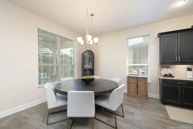 a dining room with furniture a chandelier and wooden floor