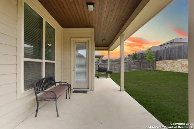 a view of a two chair and table in the back yard