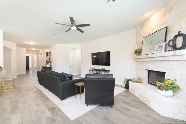 a living room with furniture a fireplace and a flat screen tv