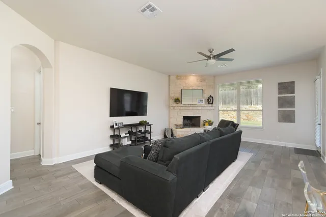 a living room with furniture a flat screen tv and a fireplace