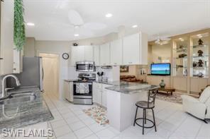 3687 El Segundo Court Naples, FL 34109 - Photo 8 of 17 a kitchen with stainless steel appliances kitchen island granite countertop a sink and cabinets