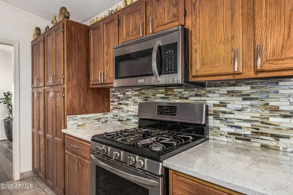 a kitchen with granite countertop a stove and a microwave