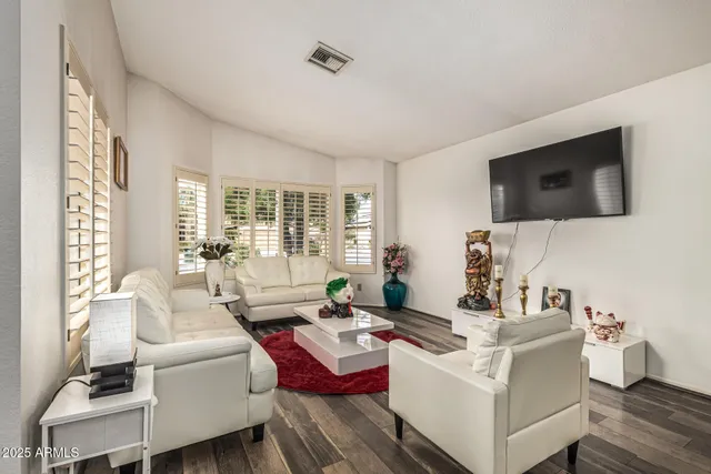 a living room with furniture a flat screen tv and a large window