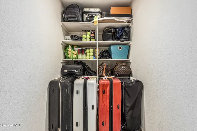 a view of walk in closet with clothes and shoes