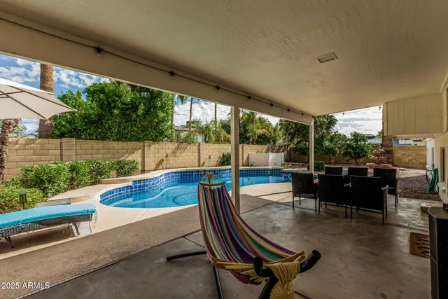 a swimming pool with outdoor seating and garden