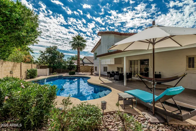 a view of a house with swimming pool and sitting area