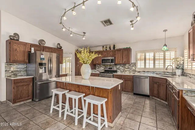 a large kitchen with granite countertop lots of counter top space and stainless steel appliances
