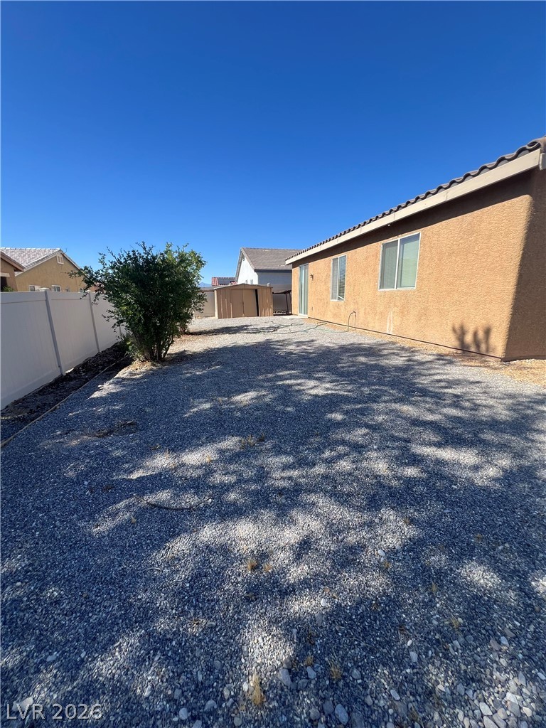 6472 Centennial Road Pahrump, NV 89048 - Photo 31 of 33 A spacious, low-maintenance gravel yard offers ample outdoor living potential, framed by a stucco exterior.
