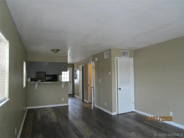a view of a kitchen with a fridge and wooden floor