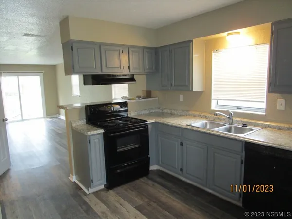 a kitchen with stainless steel appliances granite countertop a sink stove and wooden cabinets