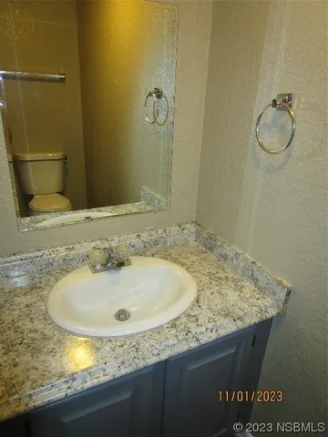a bathroom with a granite countertop sink and a mirror