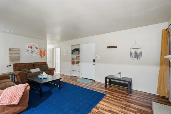 a living room with furniture and wooden floor