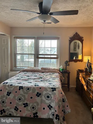 a bedroom with bed and large windows