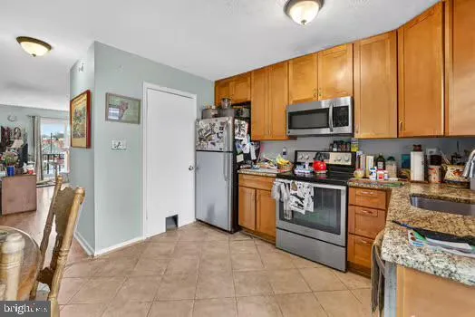 a kitchen with stainless steel appliances granite countertop a refrigerator stove top oven a sink and dishwasher