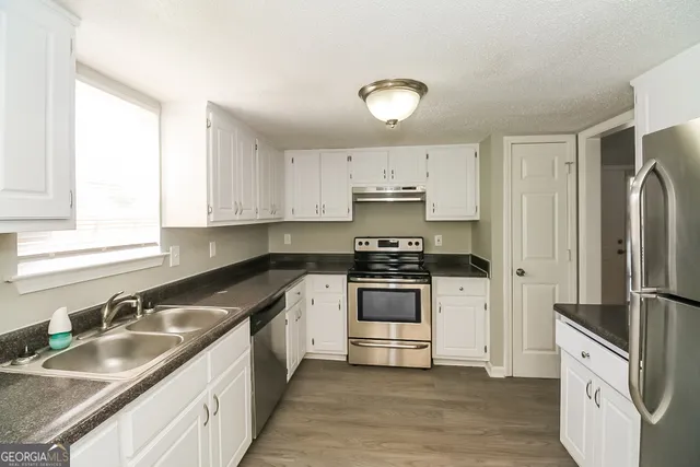 a kitchen with a sink stove and cabinets
