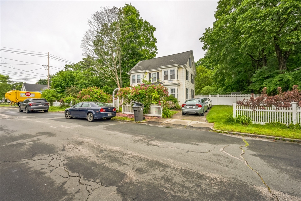 67 Meadow Street Framingham, MA 01701 - Photo 2 of 15 a view of road with card parked on side and retail shops