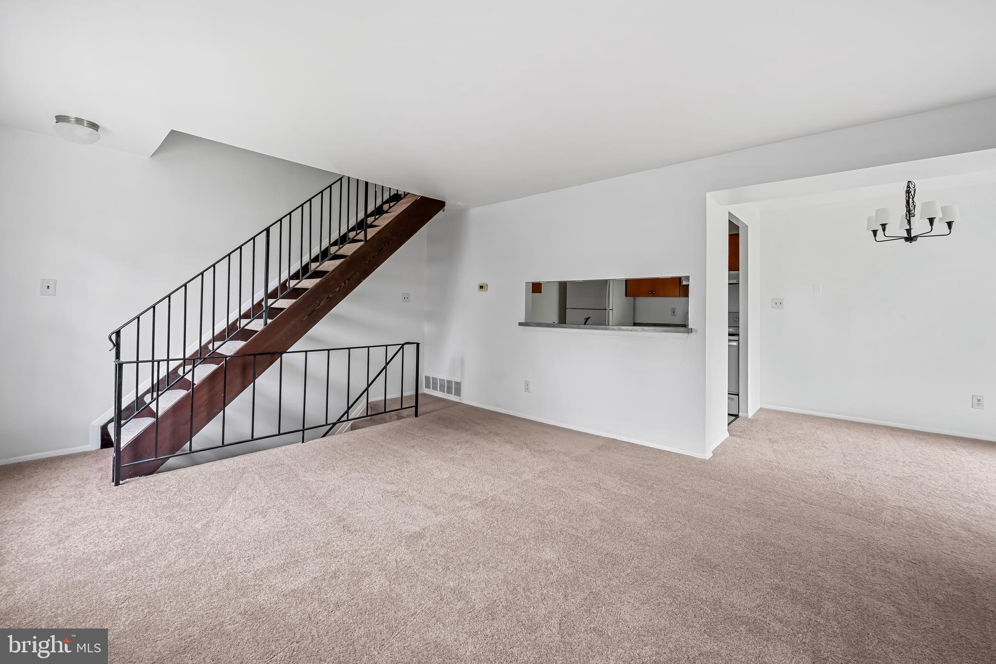 26 Mission Wood Way, Unit A Reisterstown, MD 21136 - Photo 7 of 29 a view of an empty room with stairs and a living room