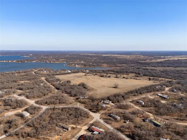 an aerial view of ocean and residential houses with outdoor space