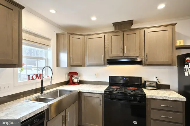 a kitchen with granite countertop a sink stainless steel appliances and cabinets