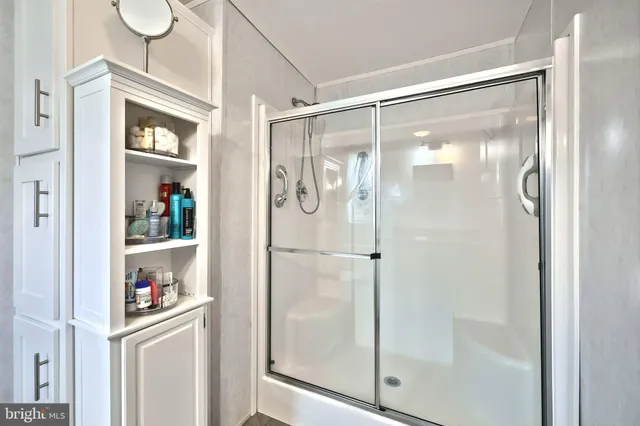 a bathroom with a glass shower door and a window