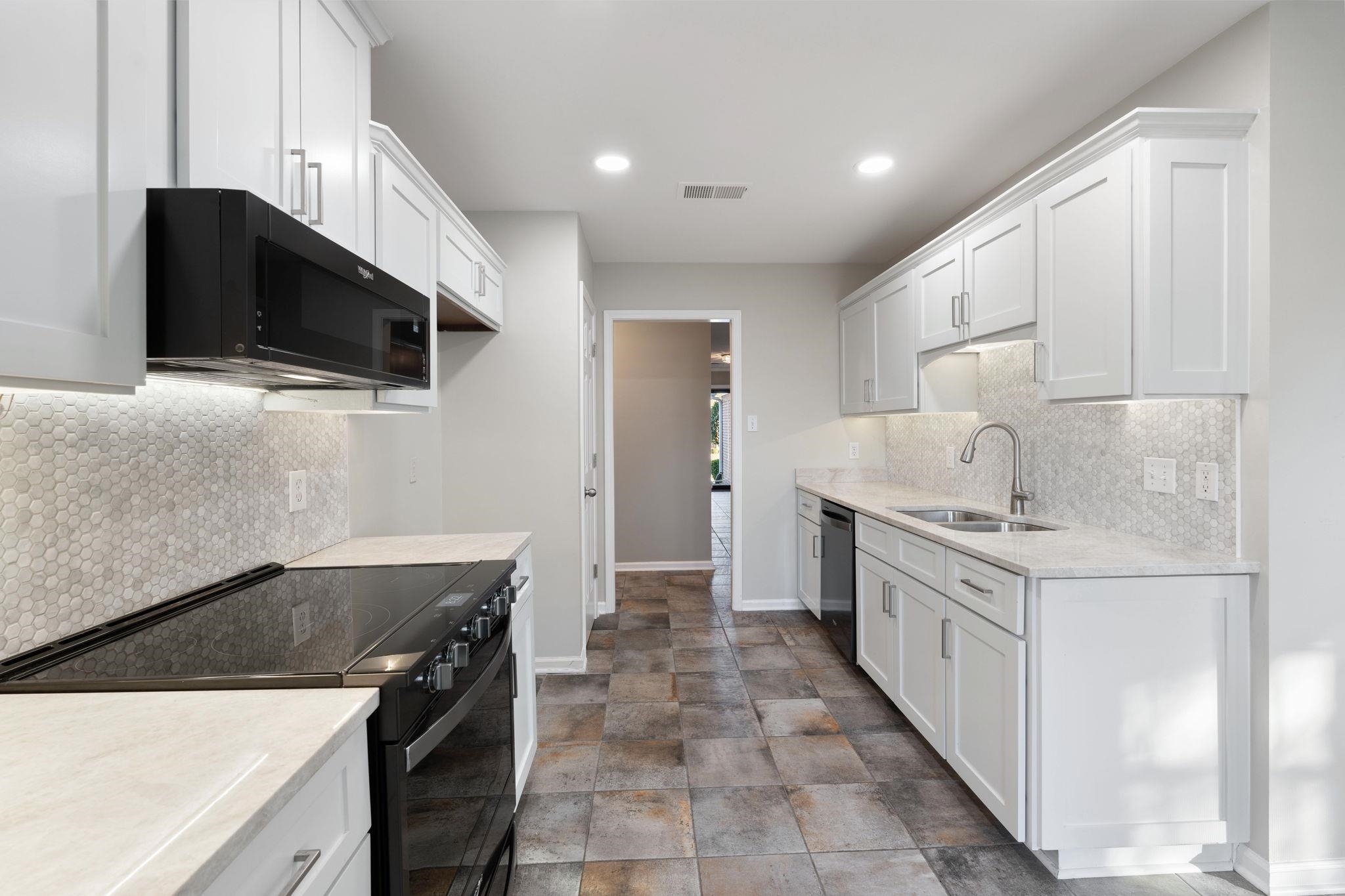 1147 Junco Cove Collierville, TN 38017 - Photo 19 of 30 a kitchen with granite countertop a sink and a stove top oven