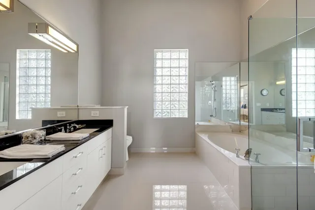 a spacious bathroom with a granite countertop sink mirror and shower