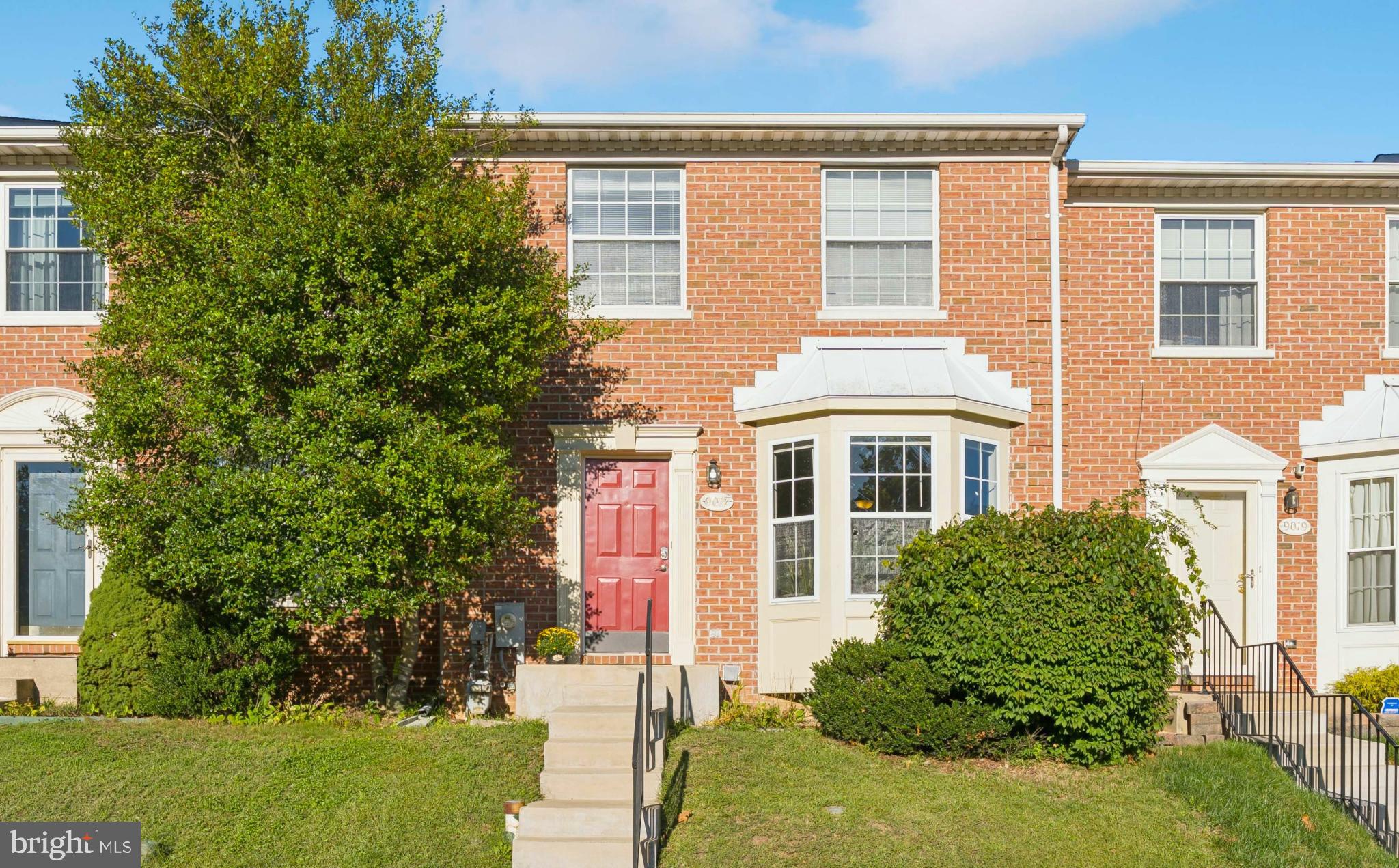 Charming brick townhouse with vibrant curb appeal.