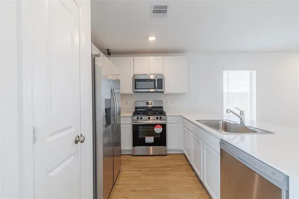 a kitchen with granite countertop a refrigerator and a sink