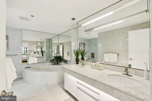a bathroom with a tub sink and mirror