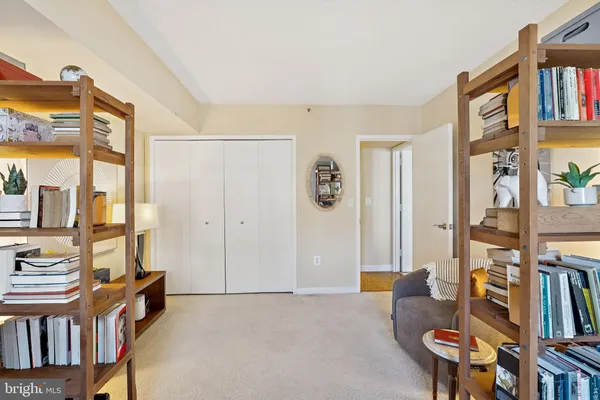 a living room with blue walls and a book shelf