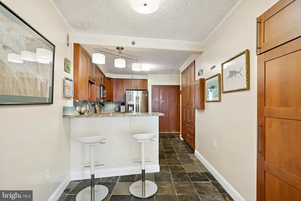 a kitchen with stainless steel appliances granite countertop a refrigerator a stove a sink dishwasher and white cabinets with wooden floor