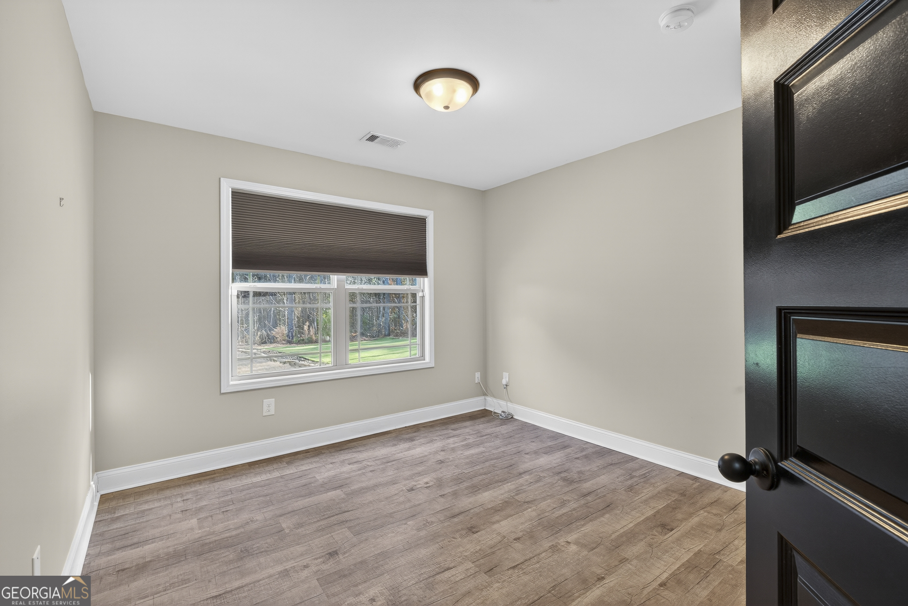 255 Needleleaf Drive Barnesville, GA 30204 - Photo 23 of 47 a view of an empty room with wooden floor and a window