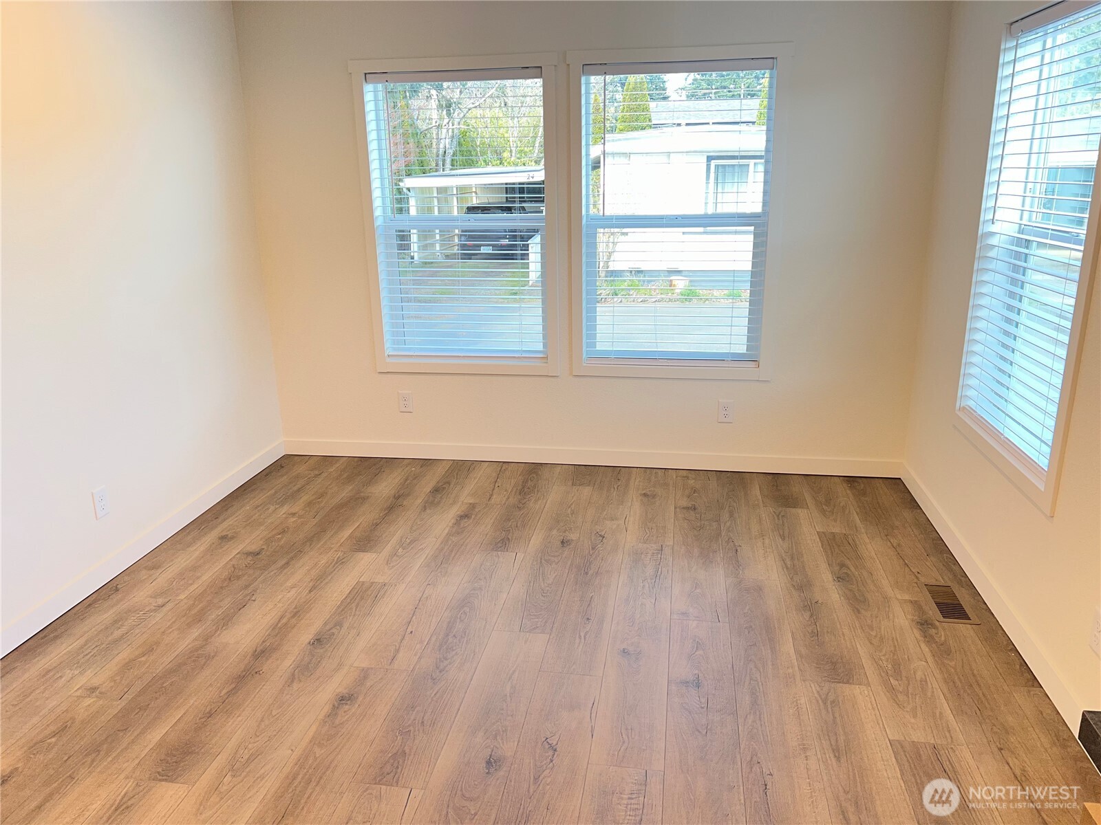 512 Southwest Berry Lake Road, Unit 21 Port Orchard, WA 98367 - Photo 5 of 19 an empty room with wooden floor and windows