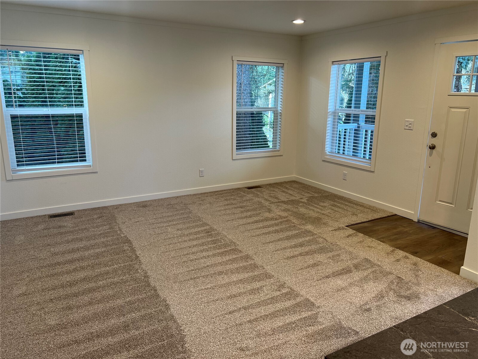 512 Southwest Berry Lake Road, Unit 21 Port Orchard, WA 98367 - Photo 7 of 19 a view of an empty room with wooden floor and a window