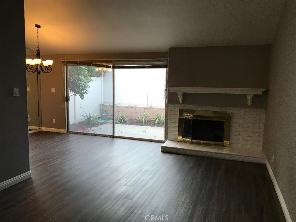 5945 Armaga Spring Road, Unit B Rancho Palos Verdes, CA 90275 - Photo 2 of 11 an empty room with wooden floor fireplace and windows