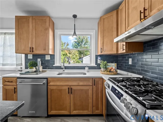 a kitchen with a stove a sink a window and cabinets