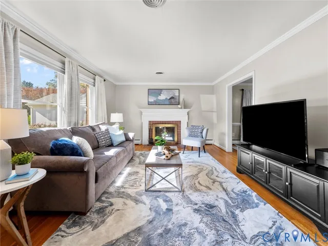a living room with furniture a flat screen tv and a fireplace