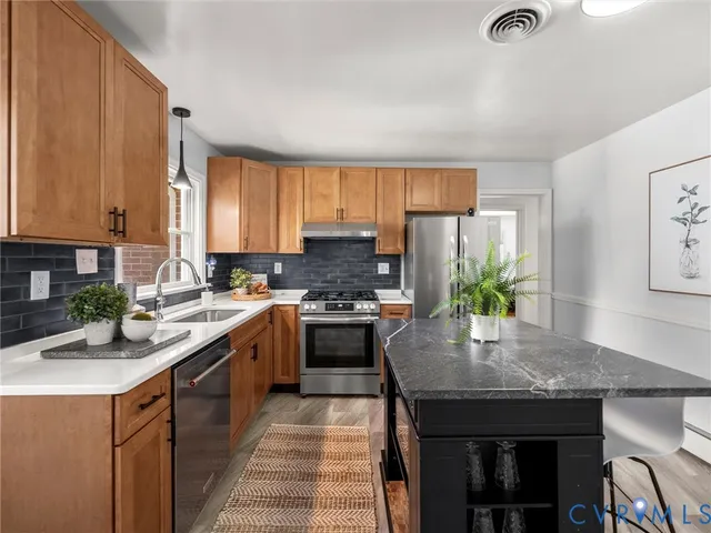 a kitchen with a stove a sink a refrigerator and a dining table