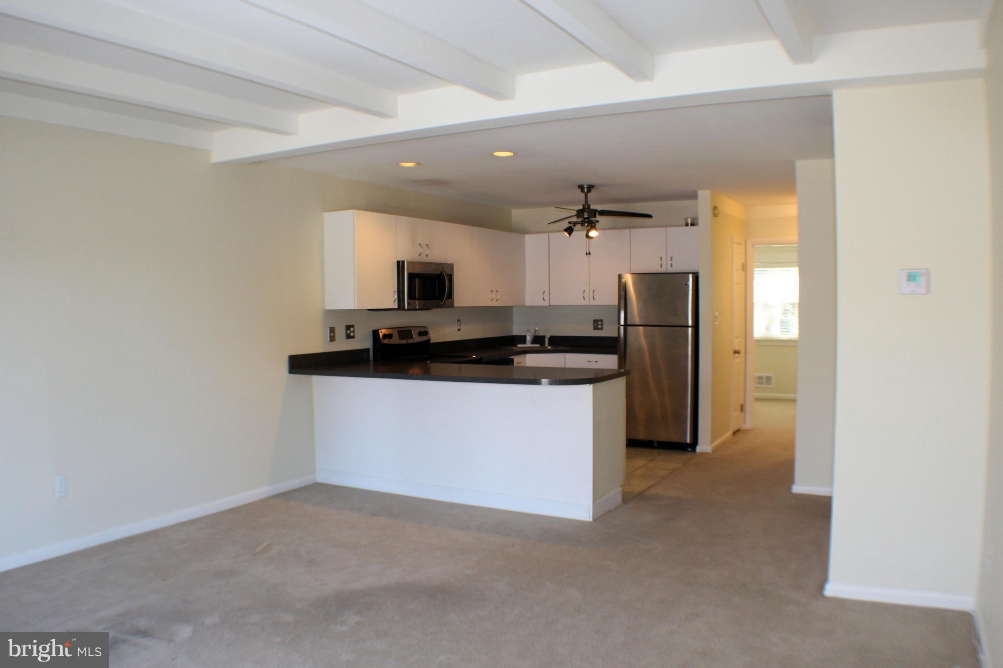 1 Center Road, Unit B4 Towson, MD 21286 - Photo 2 of 16 a kitchen with kitchen island a sink stainless steel appliances and cabinets