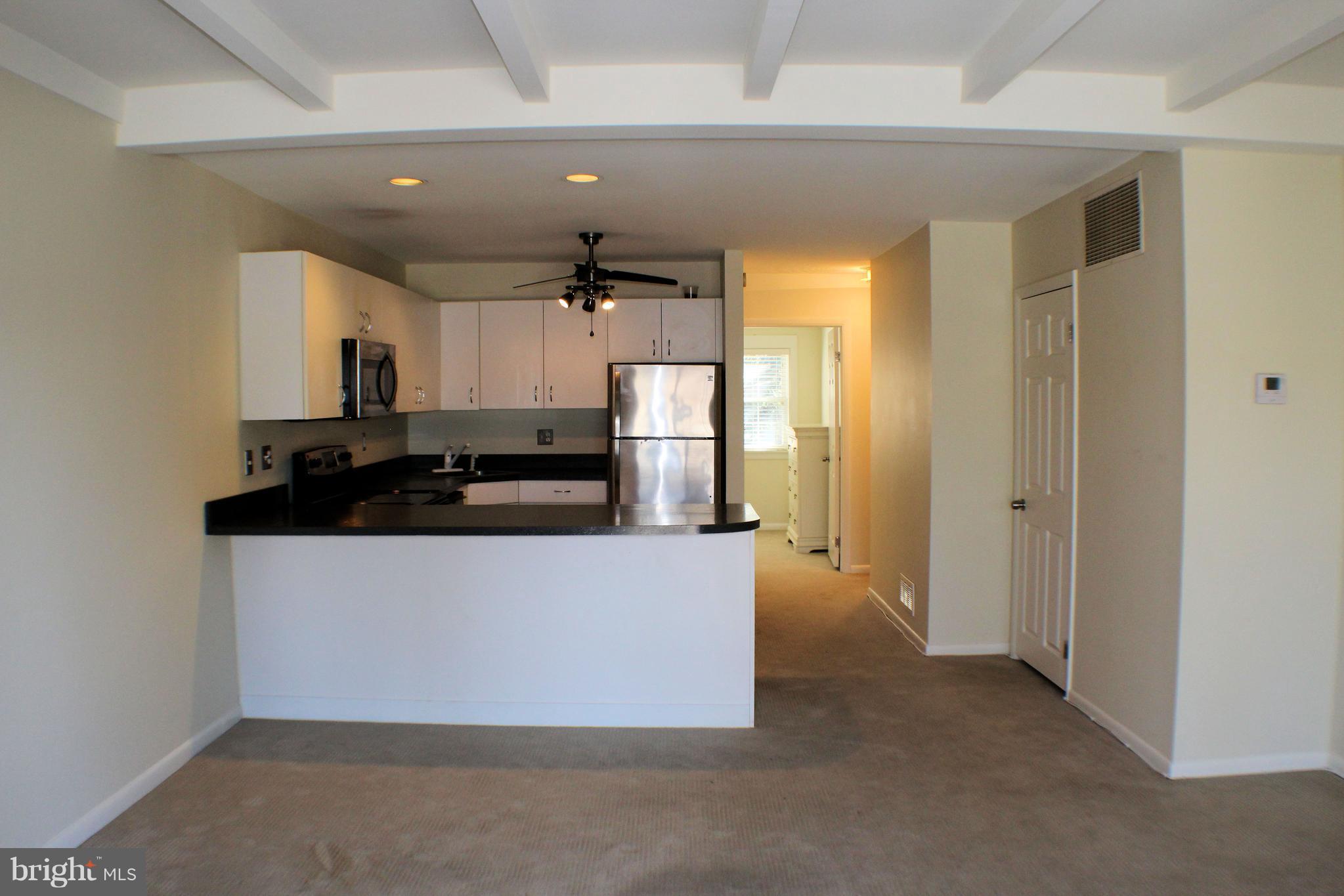 1 Center Road, Unit B4 Towson, MD 21286 - Photo 4 of 16 a living room with stainless steel appliances kitchen island granite countertop a refrigerator and a stove top oven