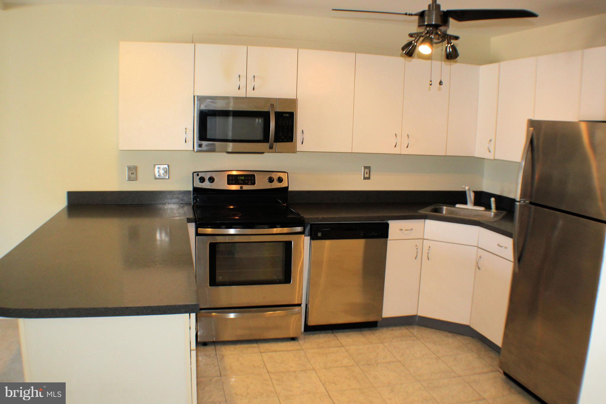 1 Center Road, Unit B4 Towson, MD 21286 - Photo 6 of 16 a kitchen with stainless steel appliances granite countertop a stove and a microwave