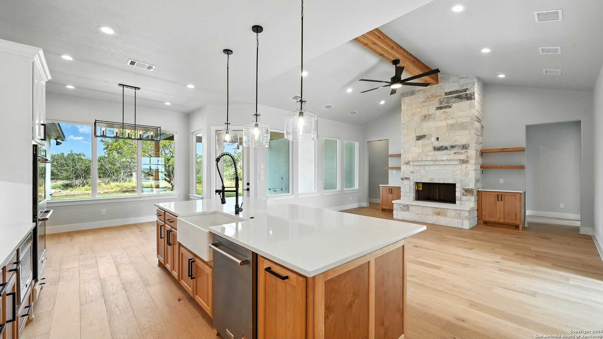 306 Toucan Drive Spring Branch, TX 78070 - Photo 16 of 50 a kitchen with stainless steel appliances kitchen island granite countertop a sink and a fireplace