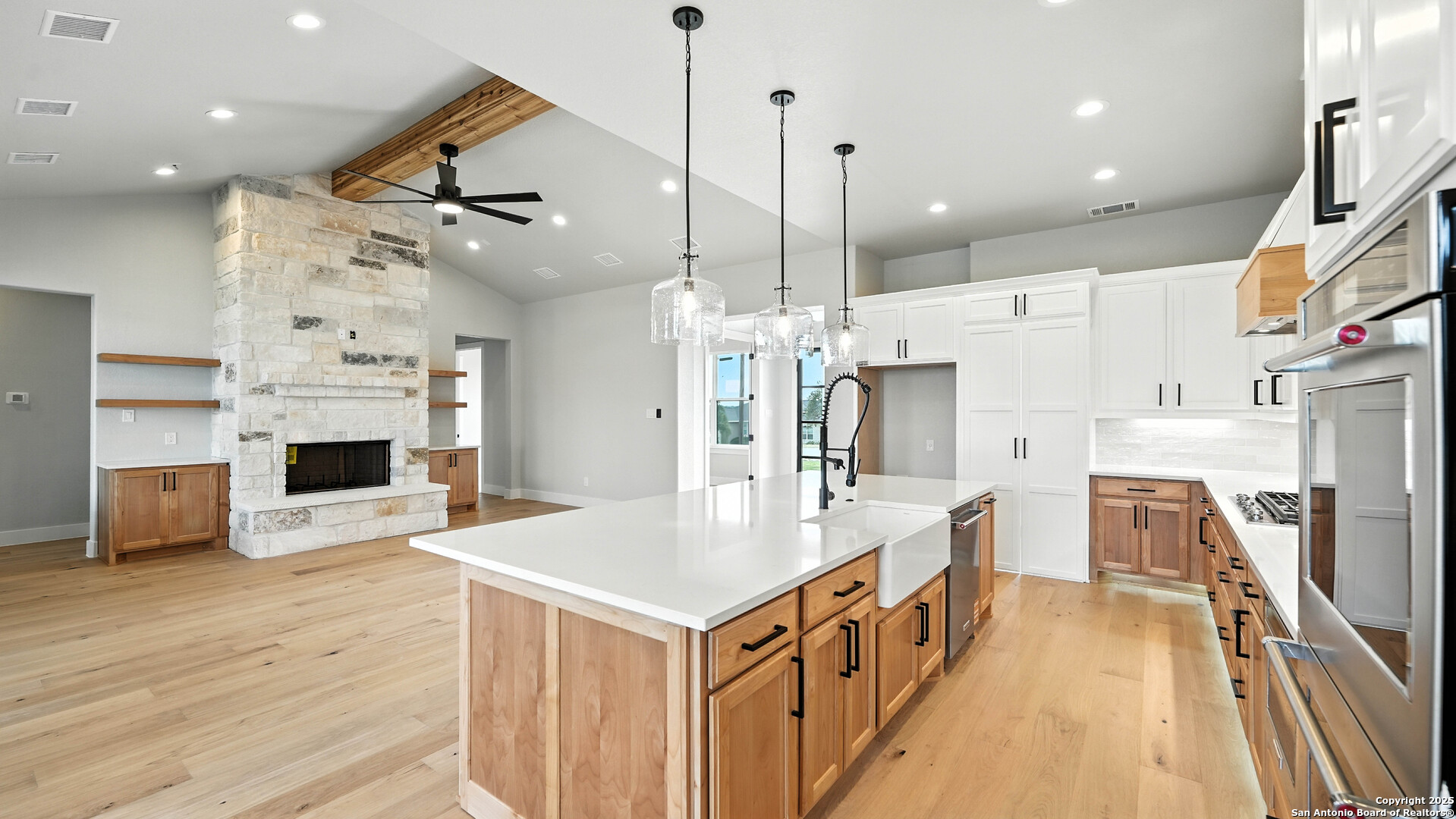 306 Toucan Drive Spring Branch, TX 78070 - Photo 21 of 50 a large white kitchen with a large island oven a stove a sink a refrigerator and a wooden floor