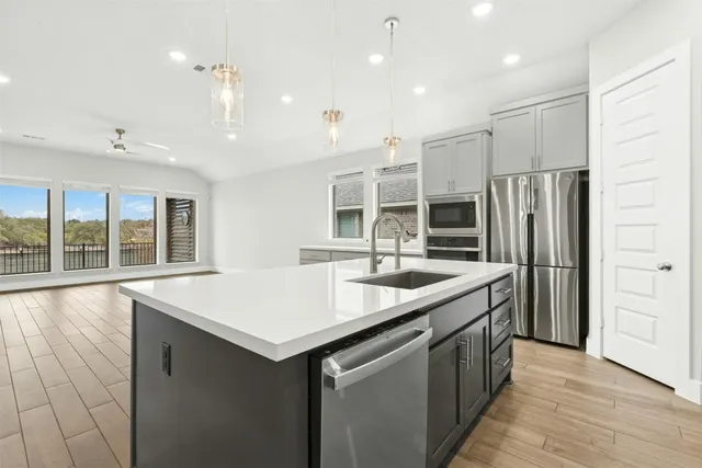 a kitchen with stainless steel appliances granite countertop a sink and refrigerator